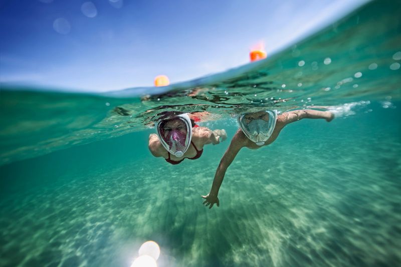 Brother and sister swimming underwater in sea. Kids are wearing modern full face masks.
Nikon D850