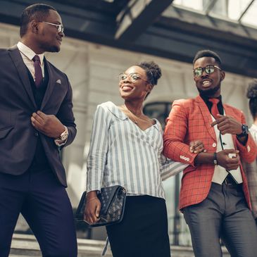 Group of stylish young professionals standing outside a modern building.