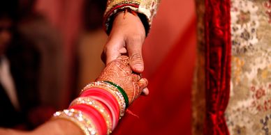 Close-up of hands joined in a traditional Indian wedding ceremony.