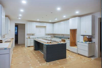 Kitchen under renovation with protective floor covering.