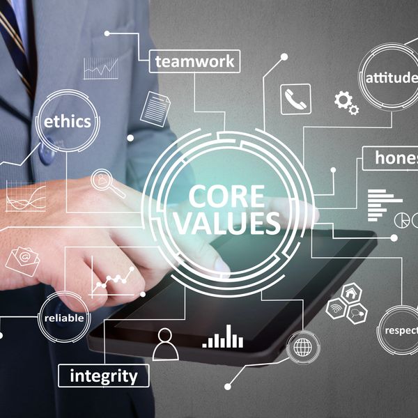 Businessman using tablet with core values like ethics and integrity highlighted followed at Zora Liiving to meet the needs of our customer for efficient & effective supply chain solutions.