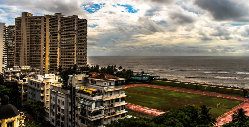 Beautiful view of Arabian Sea with horizon in the background, playground, skyscrapers, race course, from the window of multi floored apartment.