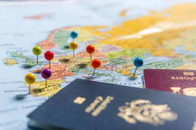Passports and colorful pins on a map.