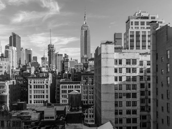 Black and white cityscape with tall buildings and the Empire State Building.