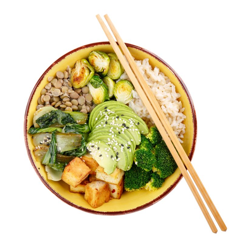 Buddha bowls isolated on white background. Colorful bowls with vegetables, healthy grains, and protein. Rice, lentils, tofu, avocado, broccoli, brussels sprouts, bok choy, sesame seeds. Healthy vegan food, vegetarian food concept. Top view.
