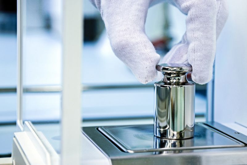 Calibration weight on an analytical balance in the laboratory