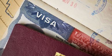 A visa and a passport inside a travel document holder.