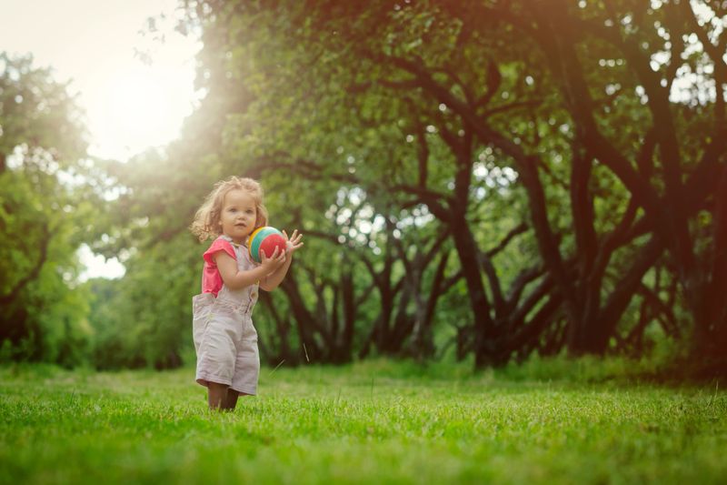 A joyful toddler playing in a colorful park, captured in natural light.