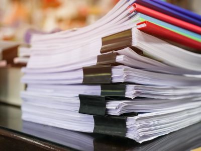 Stack of thick documents with colored tabs.