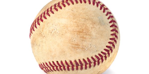 Worn baseball with red stitching.