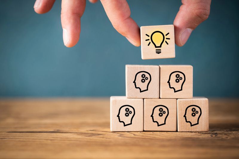 many people together having an idea symbolized by icons on cubes on wooden background