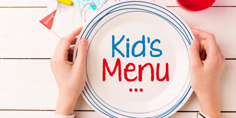 A child's hands holding a plate labeled 'Kid's Menu'.