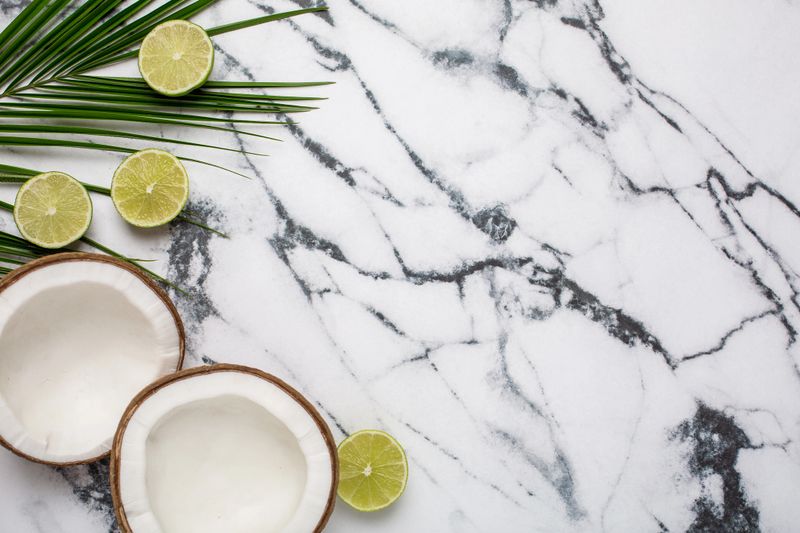 Tropical coconut, palm and lime on marble background top view