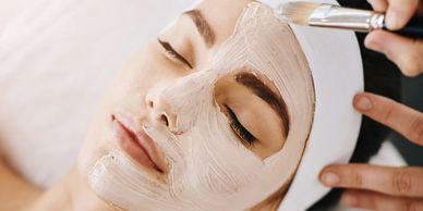Woman getting a facial mask applied.