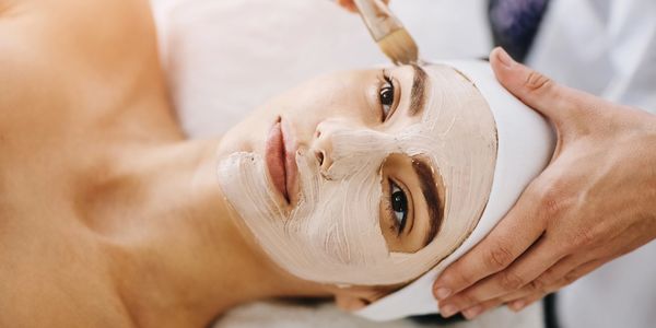 Woman receiving a facial mask treatment.