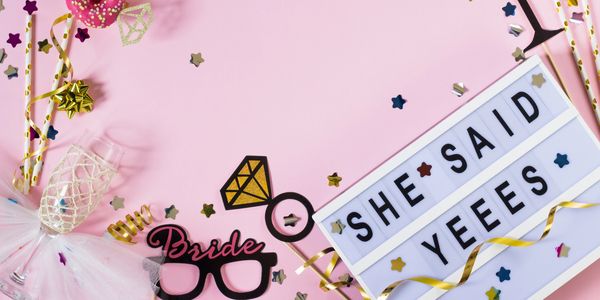 Bachelorette party decorations with pink and gold accents and a sign reading 'SHE SAID YEEES'.