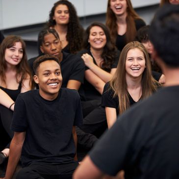 Group of young people smiling and listening.