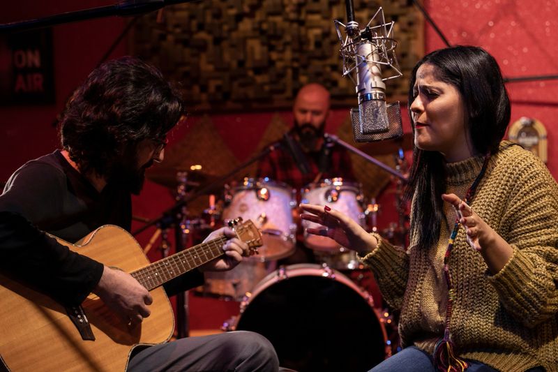 Music group performing for recording in sound studio