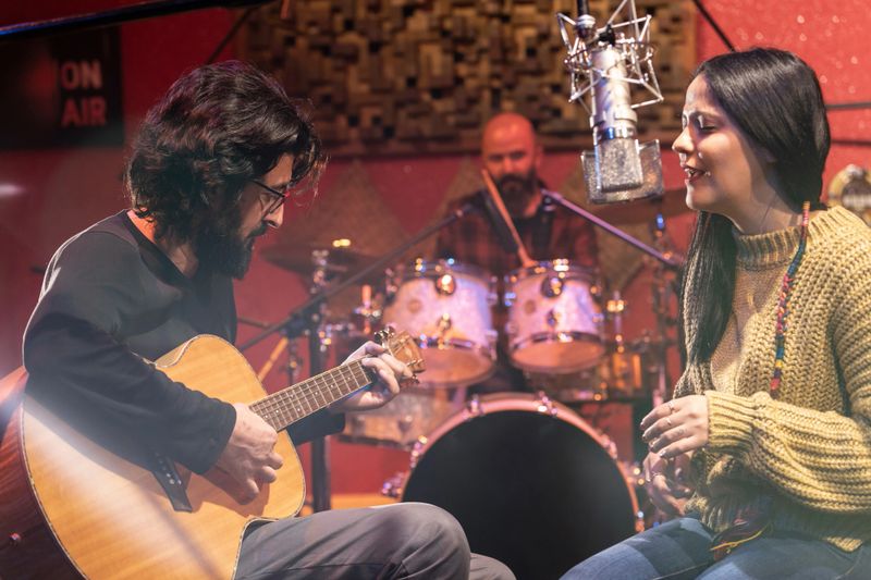 Music group performing for recording in sound studio