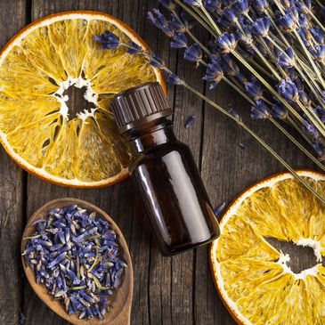 Essential oil bottle with dried lavender and orange slices.