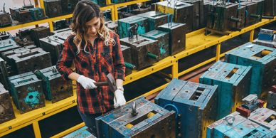 Woman working with tools in an industrial workshop.
