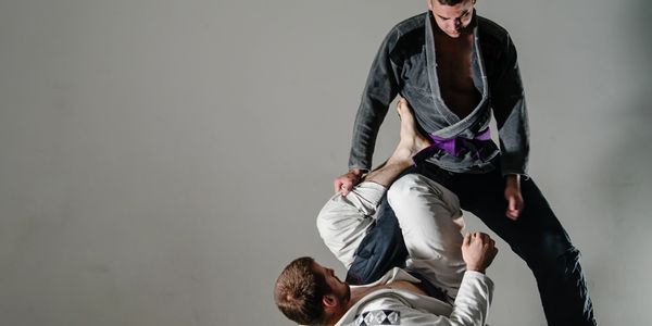Two Brazilian Jiu-Jitsu practitioners one is attempting a leg-lock.