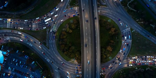 Aerial view of a busy roundabout with surrounding roads and traffic at dusk.