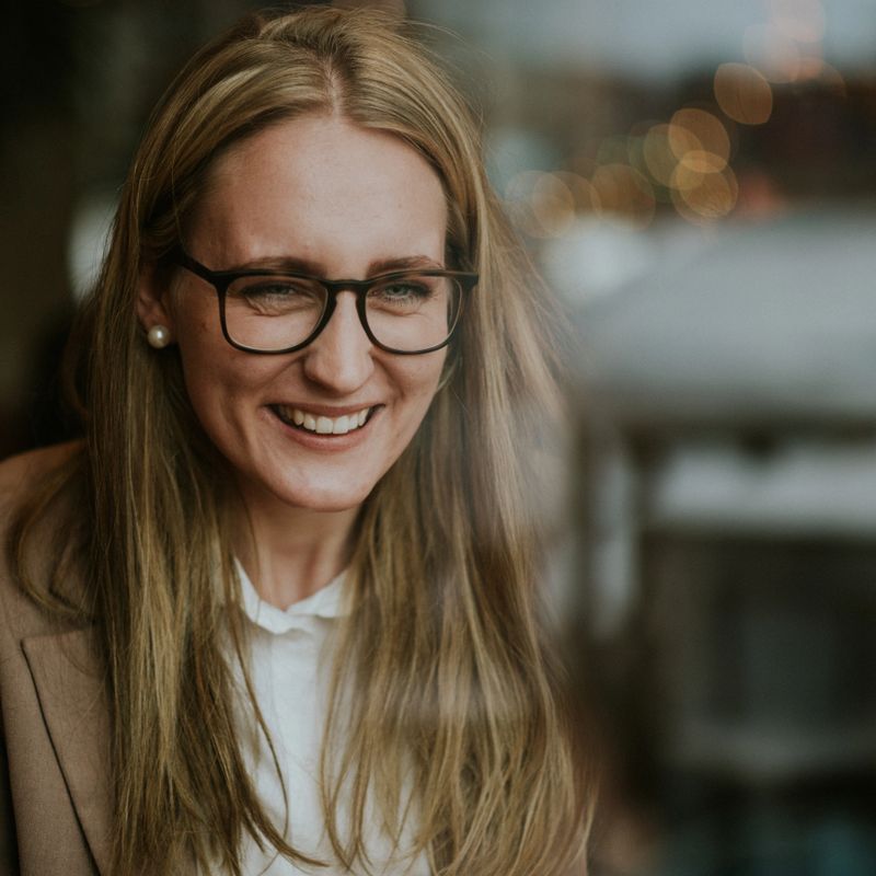portrait of a pretty young, laughing woman drinking coffee in a stylish cafe, cocoa with cream in a cafe