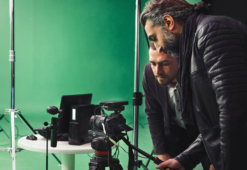 Camera operators working on backstage in green box studio