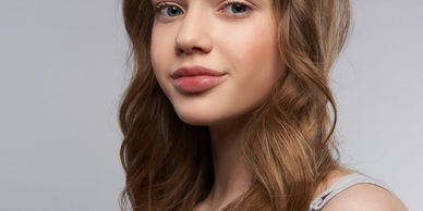 Portrait of a young woman with wavy brown hair.