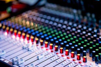 Close-up of a colorful audio mixing console with various knobs and sliders. Motorized Mic Stand 