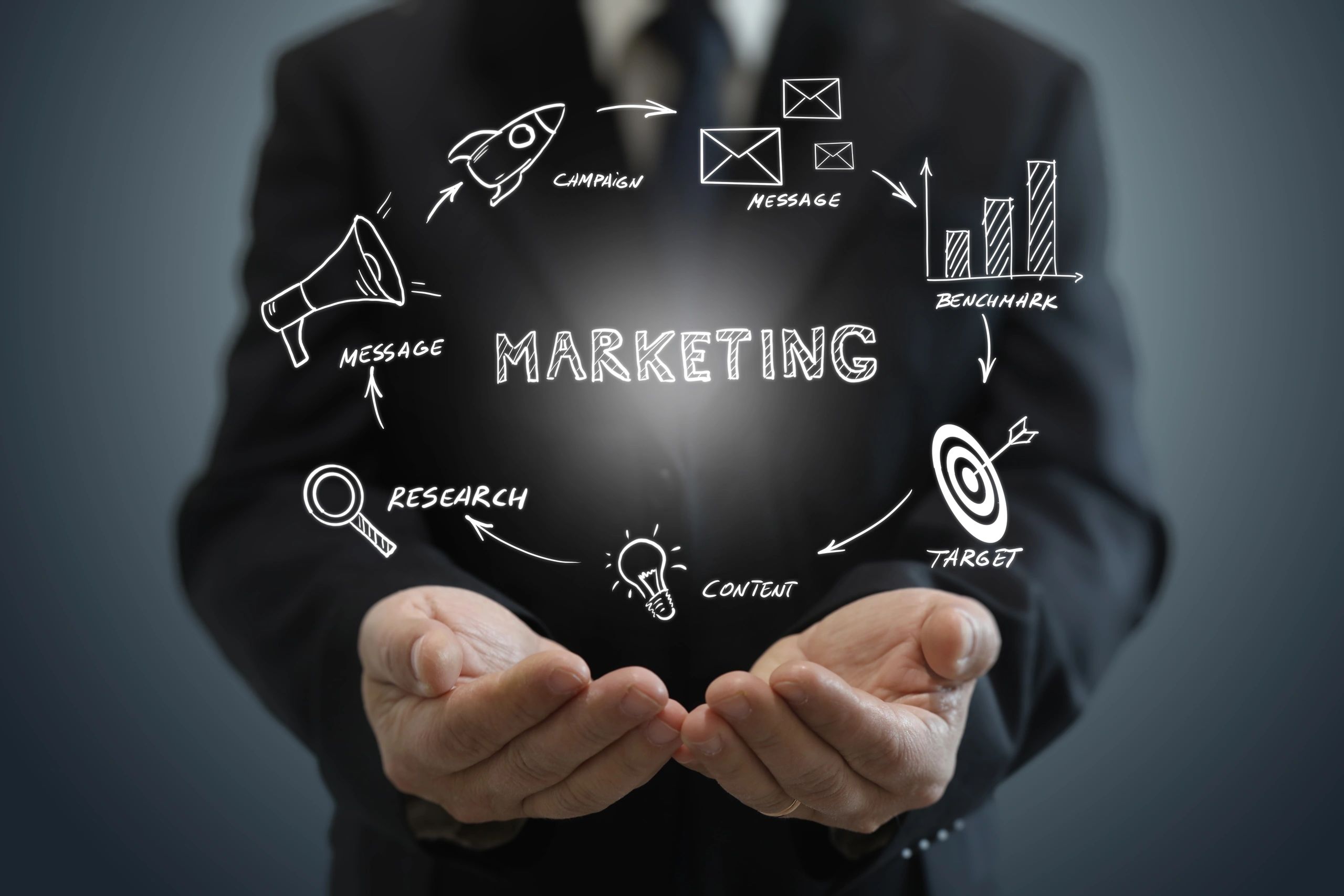 Businessman holding marketing strategy icons in hands.