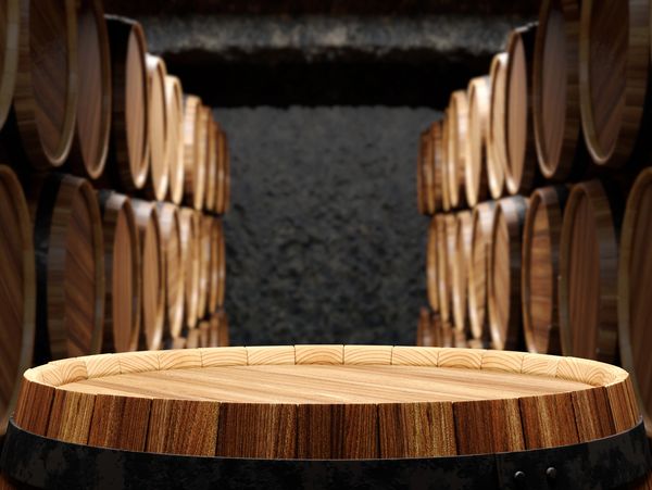 A handcrafted barrel-top tasting table in a climate-controlled barrel cellar, ideal for collectors