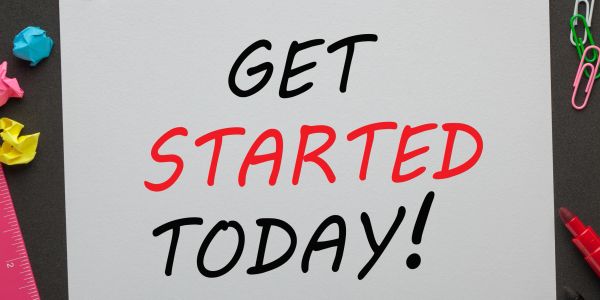 Motivational sign saying 'Get Started Today!' with colorful office supplies.
