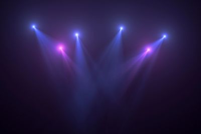 Colorful stage spotlights shining in a dark space.