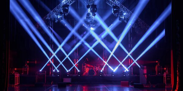 Stage set with blue spotlights and musical instruments ready for a performance.