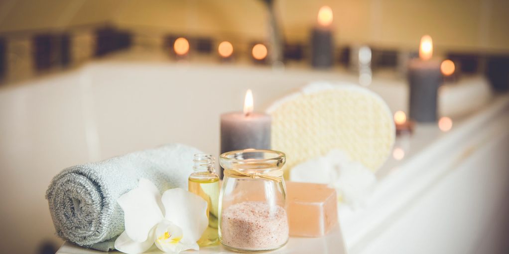 Relaxing spa setup with candles, towel, and bath essentials.