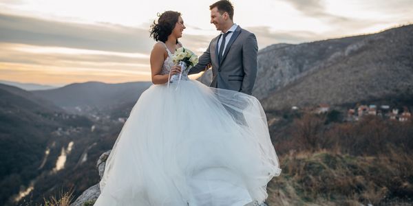 bride and groom up on a hill at sunrise