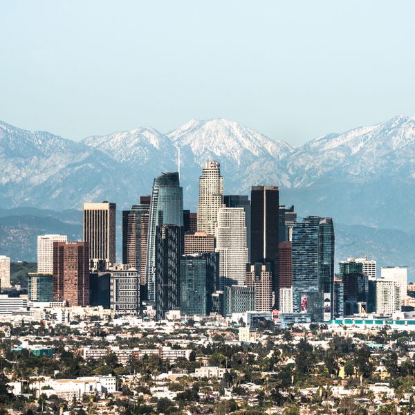 Downtown Los Angeles skyline with snow-capped mountains in the background.