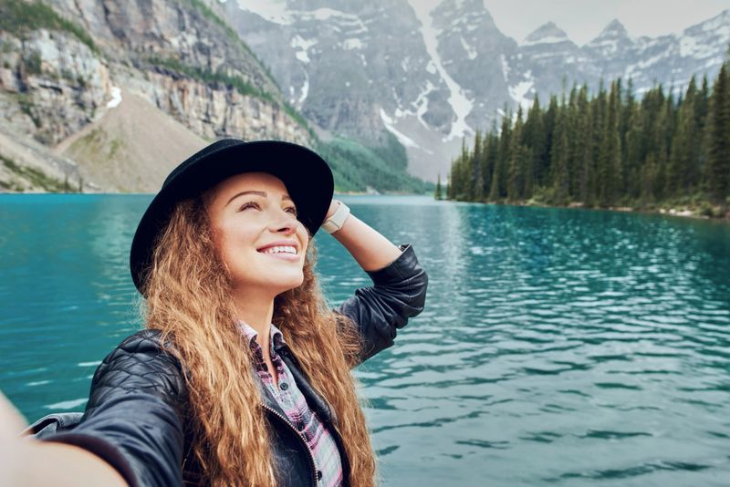 Shoot of young female traveller taking selfie of nature views