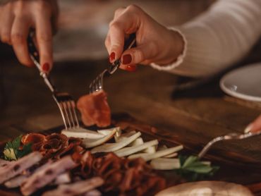 Personnes dégustant de la charcuterie avec des fourchettes.