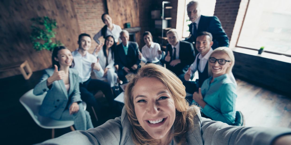 Group of business professionals taking a cheerful selfie.