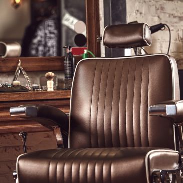 Brown leather barber chair in a vintage barbershop.