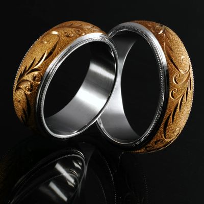 Matching wedding bands in palladium white gold and 18K yellow gold with bright-cut scrollwork on a m