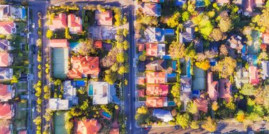 Aerial view of a suburban neighborhood with houses, roads, and greenery.