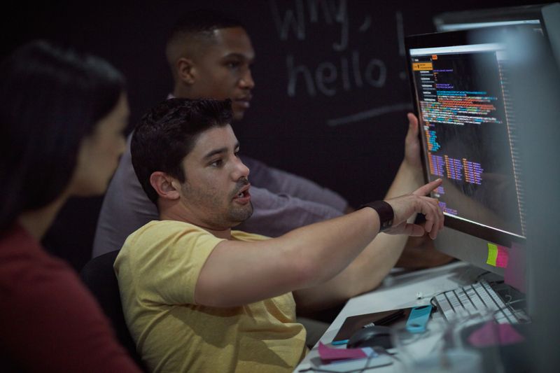 Shot of a group of young businesspeople working on a computer network during a late night at work