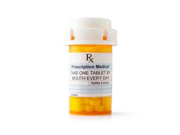 Orange prescription pill bottle with daily dosage instructions.