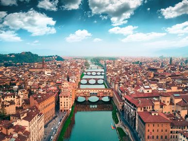 A scenic aerial view of a European city with multiple bridges over a river.