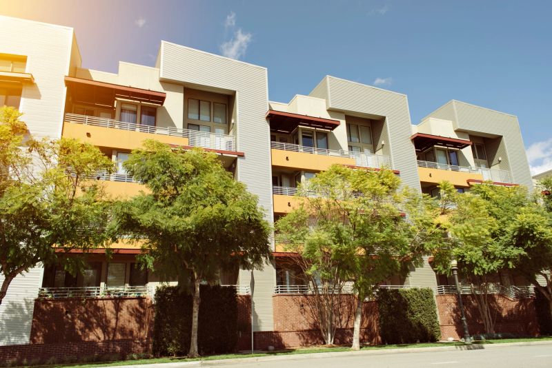 View of modern apartment building on a sunny day with warm lighting