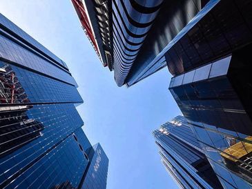 Looking up at skyscrapers in black and white.